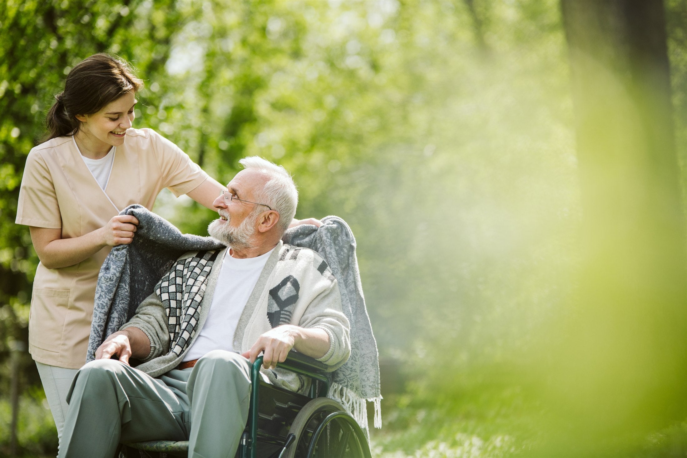 Caregiver offering calm support to an older patient outdoors